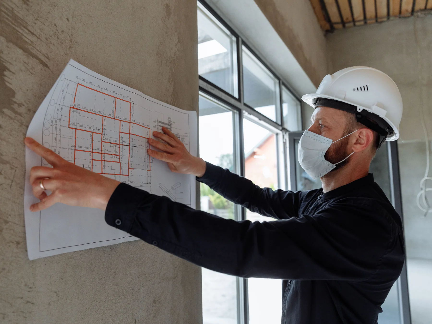Fachkraft prüft einen Bauplan auf einer Baustelle